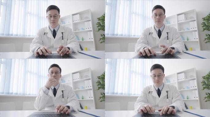 严肃的亚洲治疗师在电脑键盘上打字，在线医疗咨询