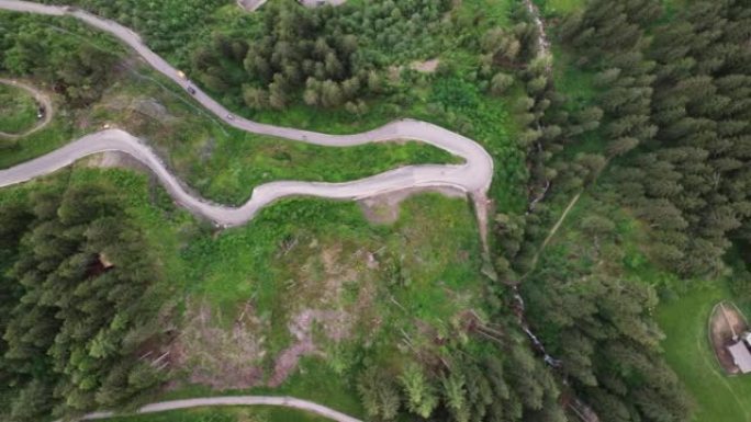 风景秀丽的无人机4k视频镜头，在多洛米特斯阿尔卑斯山的松树林中隐藏着蛇形弯曲的道路