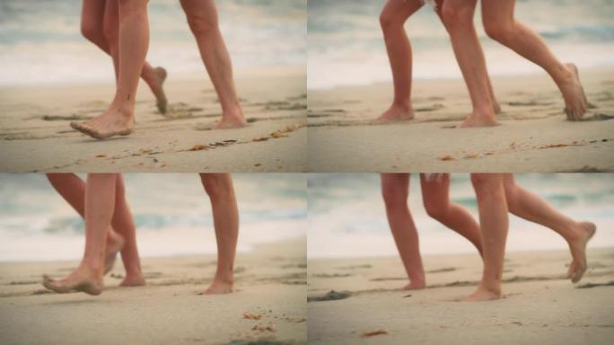 特写两个人的脚走出大海，在海滩上行走