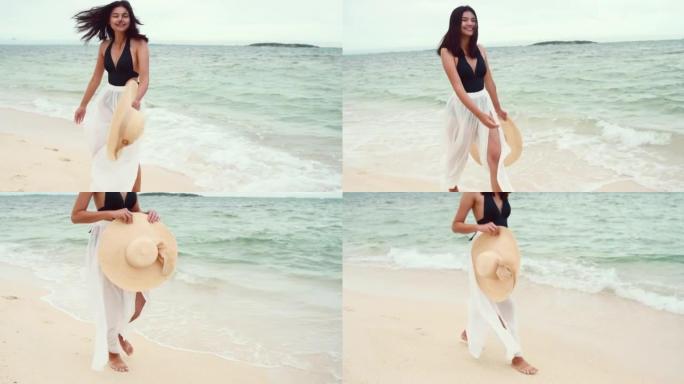 美丽的年轻亚洲女人在海滩上散步。