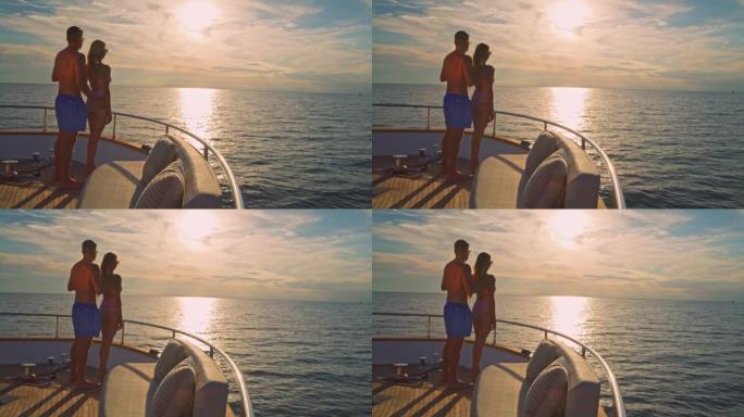 SLO MO DS夫妇站在游艇的船头，看着平静的大海