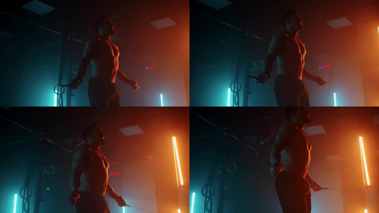 赤裸上身的肌肉男正在用跳绳跳跃。跳绳的男子拳击手。在彩色灯光和烟雾的慢动作中，选手在做跳绳练习。