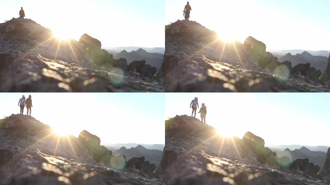 女徒步旅行者沿着山脊到达山顶，日出