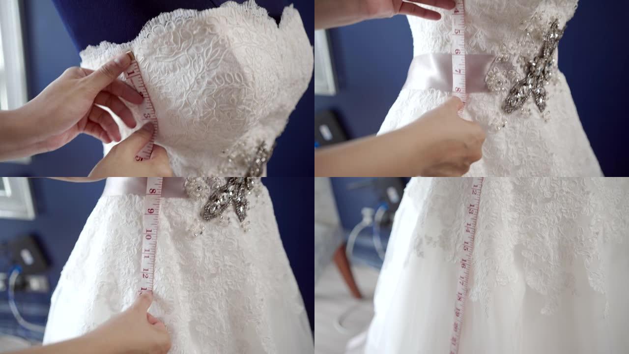 小型企业的婚礼服装业务，在商店里缝制白色婚纱。