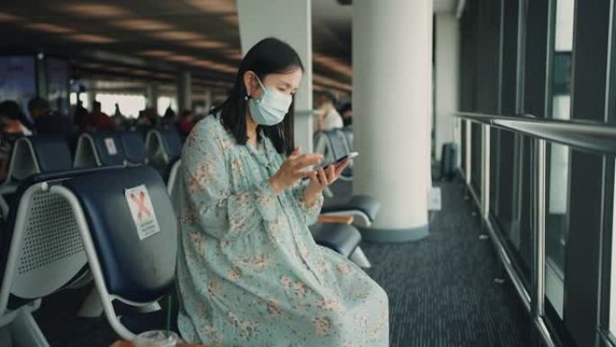 女乘客在等待新的旅程时玩着智能手机。