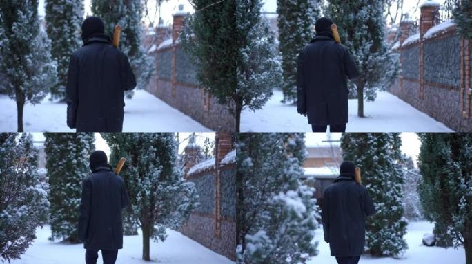 背景网窃贼与棒球棒走在户外白雪皑皑的后院。现场摄像机跟随自信的男子戴着滑雪面具漫步在白雪上环顾四周。
