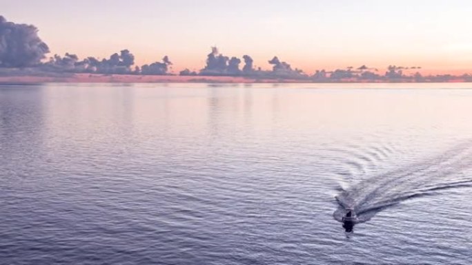 空中无人驾驶飞机在日落时分在海洋上拍摄小船