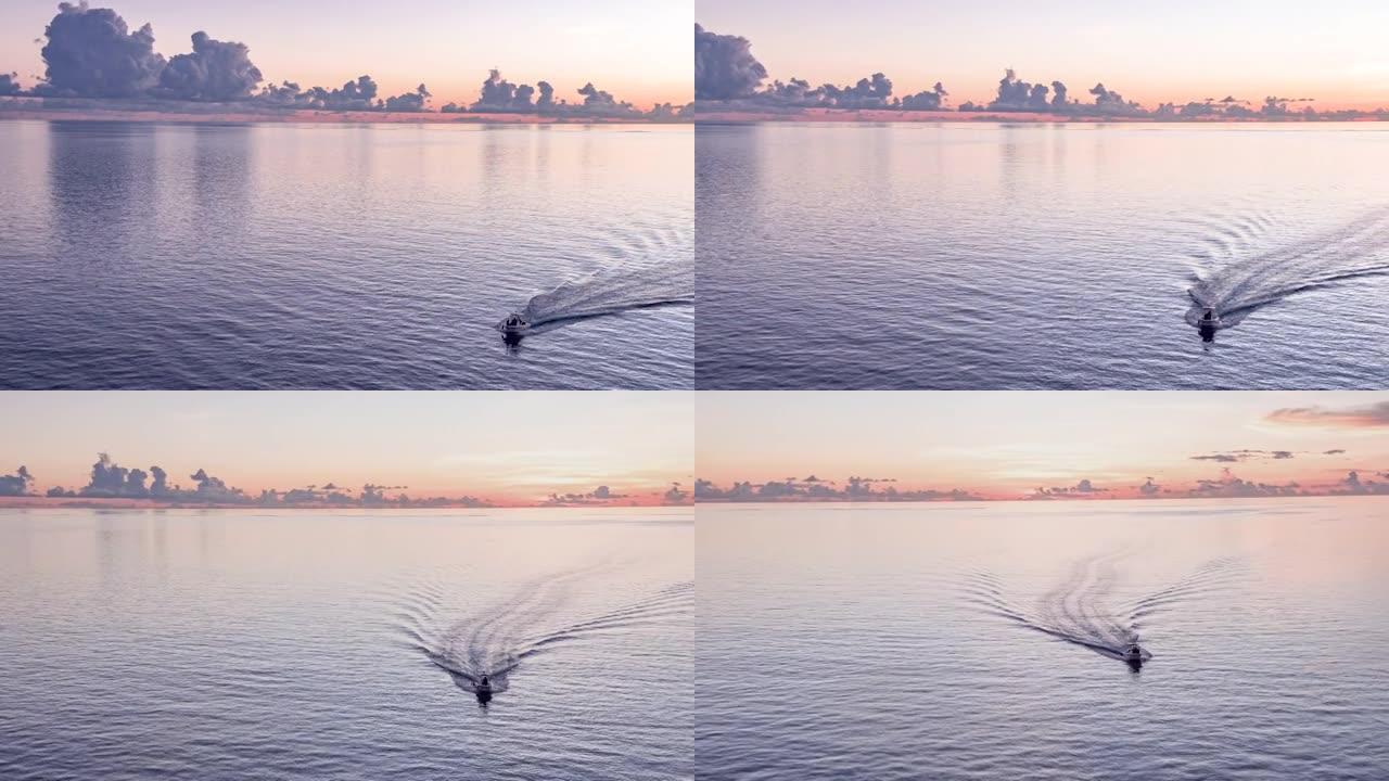 空中无人驾驶飞机在日落时分在海洋上拍摄小船