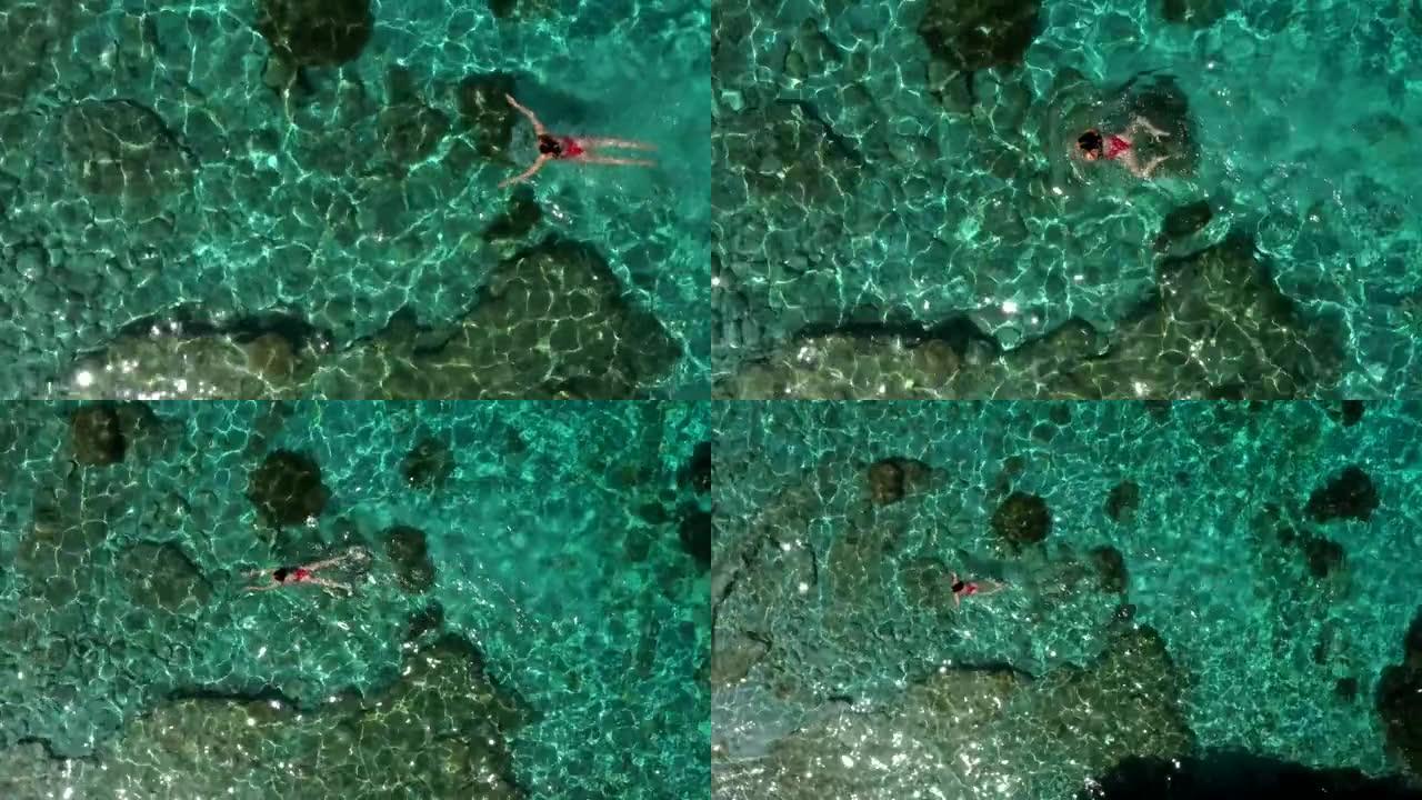 空中无人机拍摄了一名在海洋中游泳的妇女