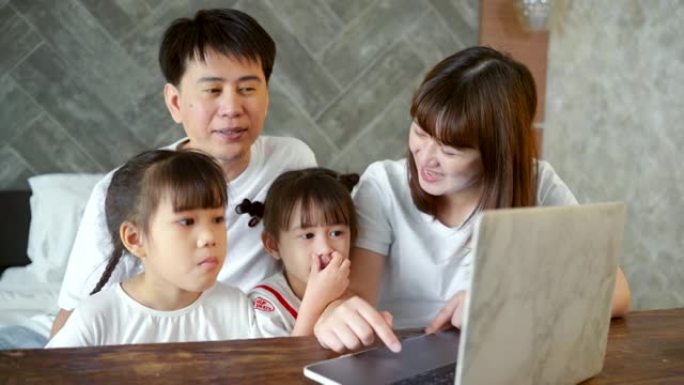 社交电话会议，亚洲女儿和父母通过带有无线互联网系统的计算机上在线课程。