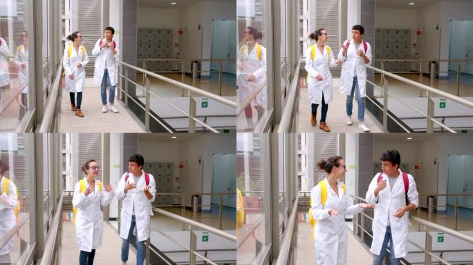 拉丁美洲开朗的医学院学生在大学的走廊里走来走去，背着背包，一边说话一边穿着实验服