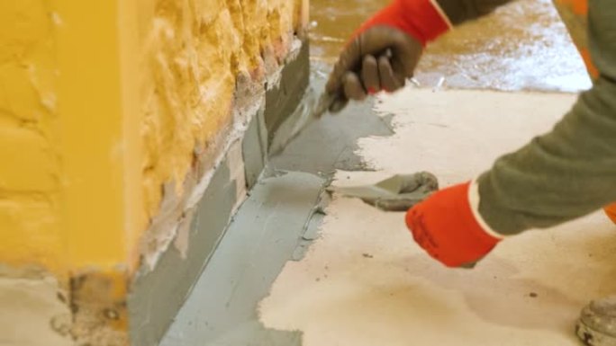 双手用刮铲将墙壁的突起与地板上的腻子。