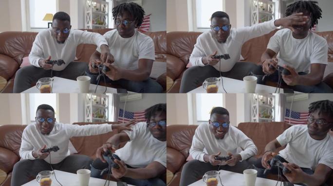 快乐的非洲裔美国人在视频游戏中作弊，闭上朋友的眼睛。积极的男性朋友周末在客厅玩在线游戏。现代生活方式