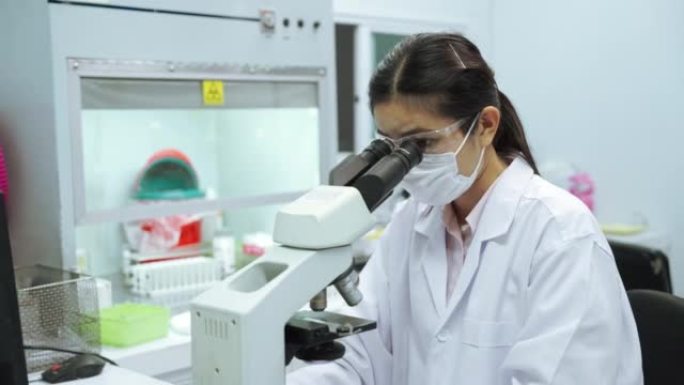 实验室技术员在显微镜室研究和开发抗病毒药物。