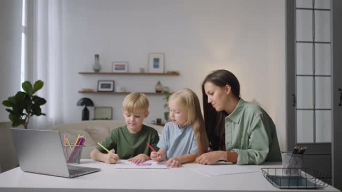 一位年轻的母亲或保姆帮助两个金发碧眼的孩子在看笔记本电脑时完成一项任务。帮助课程和家庭作业
