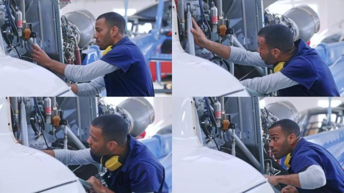 年轻男性航空维修技师检查直升机的变速箱