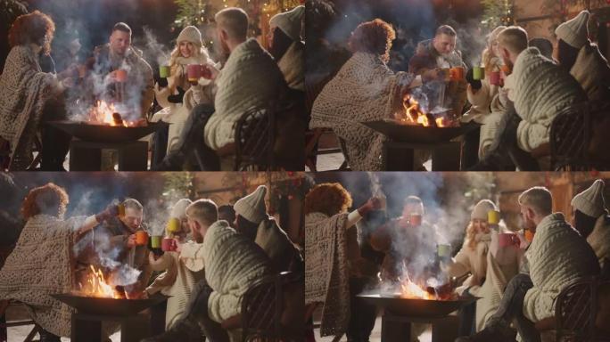 冬季晚上圣诞快乐派对，一群多民族朋友在篝火上叮当