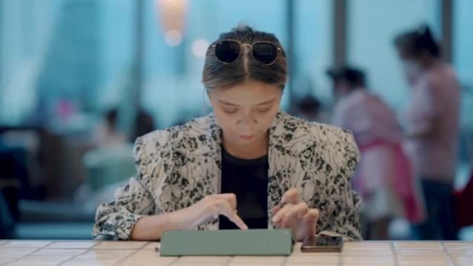 亚洲成年女性在合作空间做笔记，在线课堂讲师授课。