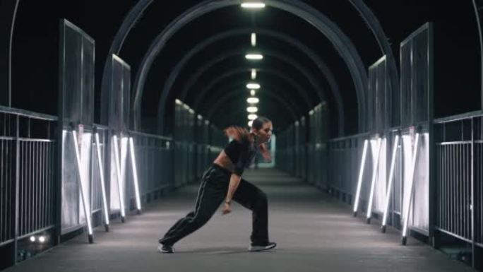 女嘻哈舞者正在地铁穿越，快闪和挑战的黑暗隧道中移动