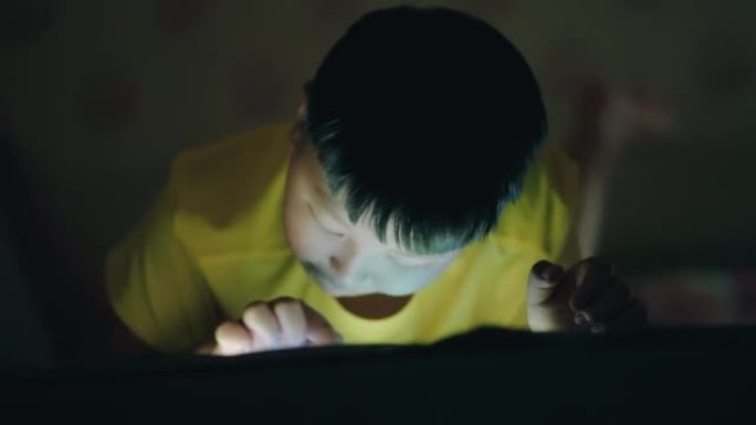 亚洲男孩使用平板电脑，儿童近视。