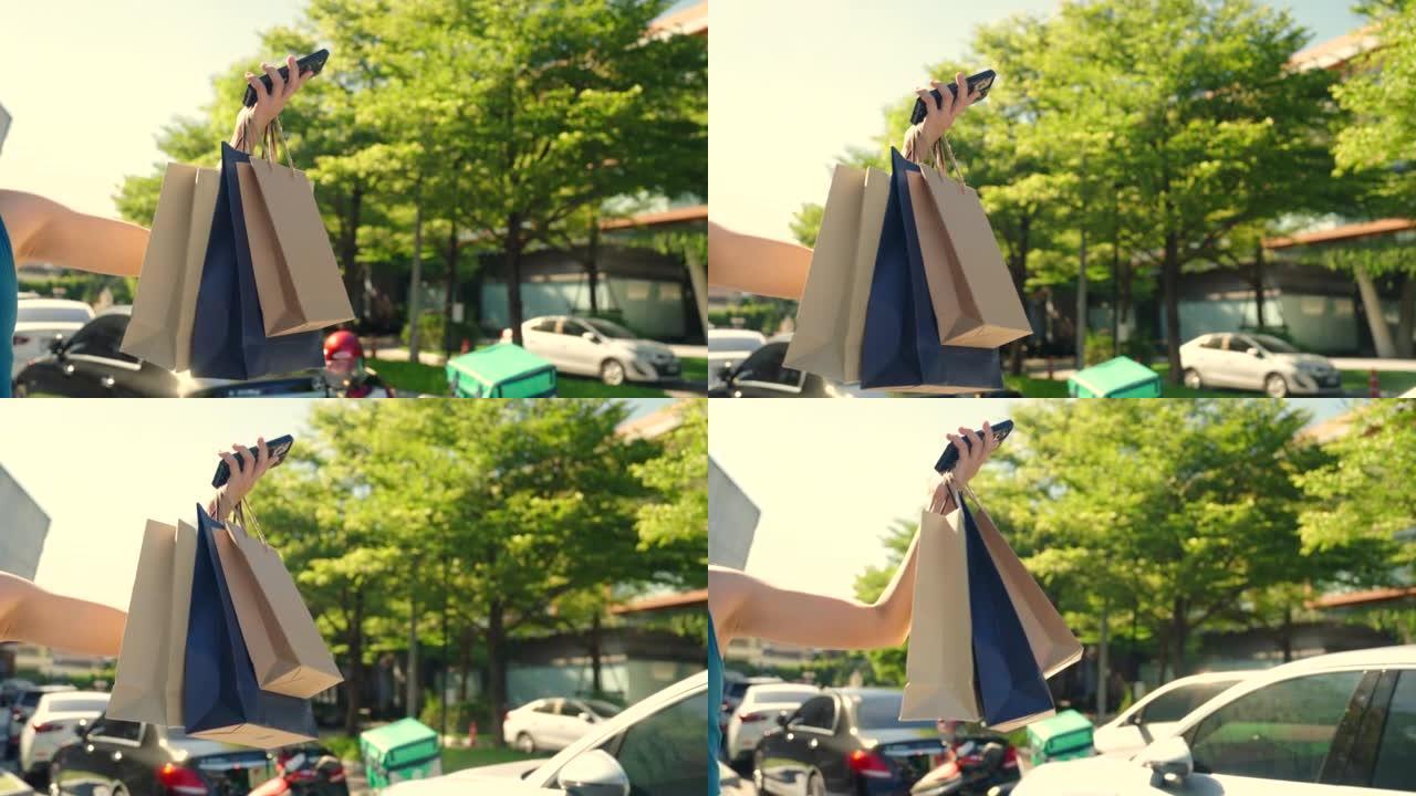 亚洲女人在户外购物中心购物后步行购物袋。