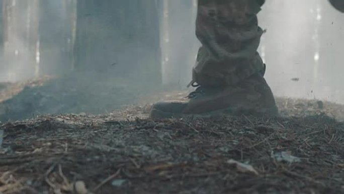 在烟雾弥漫的森林中奔跑的士兵靴子的特写镜头