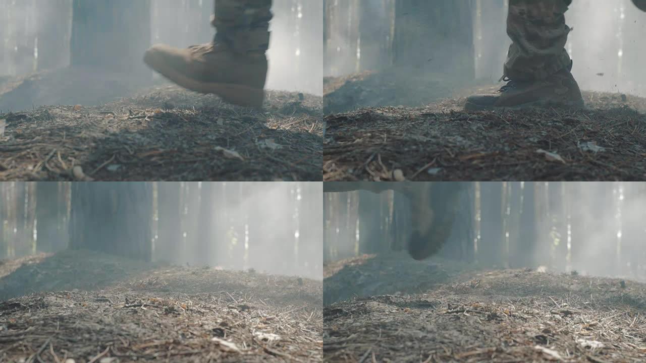 在烟雾弥漫的森林中奔跑的士兵靴子的特写镜头