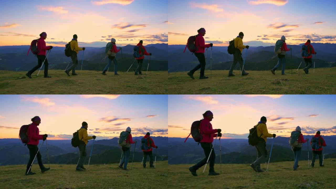 SLO MO TS四名徒步旅行者在日落时分穿过山间草地