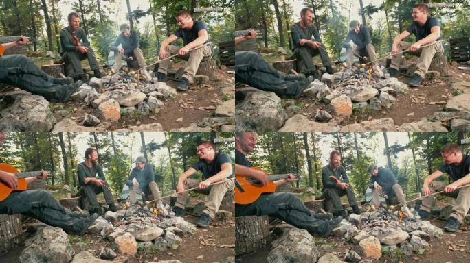 男人坐在篝火旁烧烤土豆和唱歌