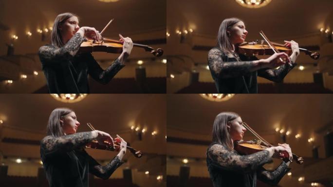 才华横溢的女小提琴家正在老歌剧院拉小提琴，是受启发的女音乐家的肖像