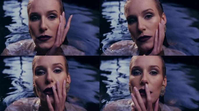 浮动放松。诱人的女人从黑暗的水中冒出来。抚摸她的长发和柔软的皮肤。奢华美容护理