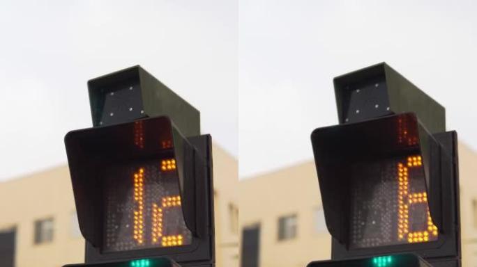 行人交通信号灯标志的垂直特写视图。绿灯，倒计时时间变为红色停车灯。是时候安全过马路了