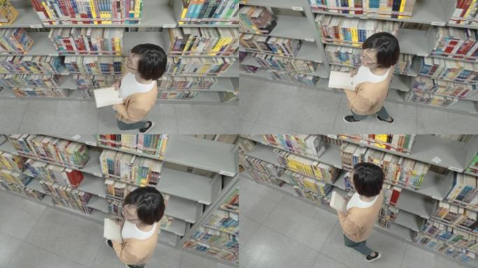 亚洲妇女在图书馆寻找书籍