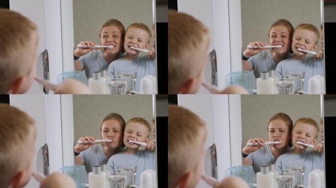 母子俩在浴室里用电动牙刷刷牙。