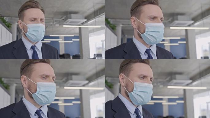 戴着医疗面具的不快乐商人站在空荡荡的办公室，大流行危机