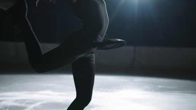 年轻的运动女人在溜冰场上旋转，运动女孩在比赛前穿着黑色衣服进行训练，排练程序和元素