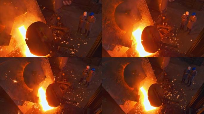 CS当熔融金属倒入钢包时，两名主管站在铸造厂