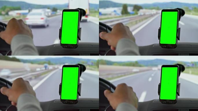 男子在高速公路上开车，看着智能手机上的导航