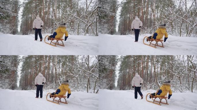 当他的母亲将他拉过森林里的积雪时，小孩正坐在雪橇上