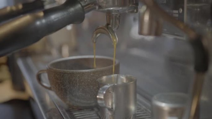 咖啡从浓缩咖啡机滴入杯子的细节照片