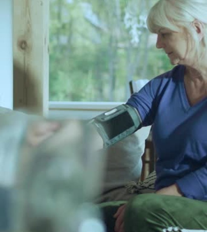 女医生在体检时测量老年患者的血压垂直视频