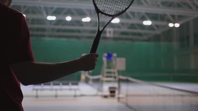 成年运动员手持网球拍，手臂温暖，特写镜头，场上职业球员