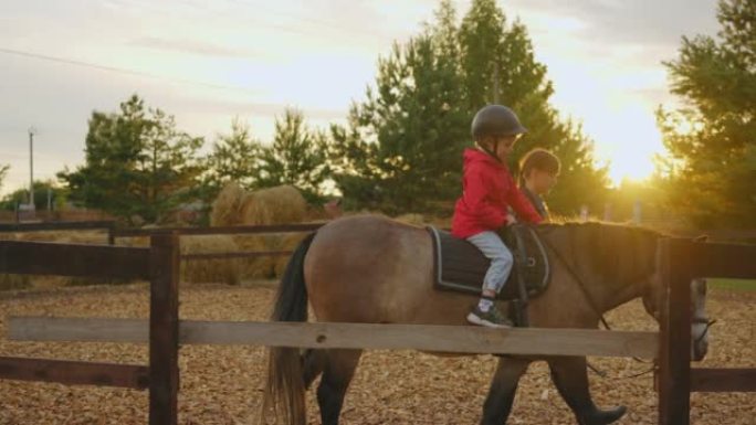 小马俱乐部的海马疗法和骑马疗法，小男孩和女教练在围场练习
