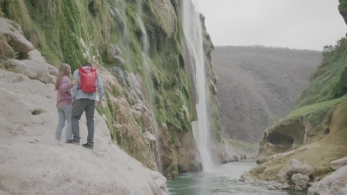 徒步旅行时探索河流和瀑布的年轻男女