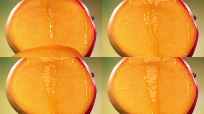 将芒果减半，果汁从旋转减半的芒果王表面流下。慢动作