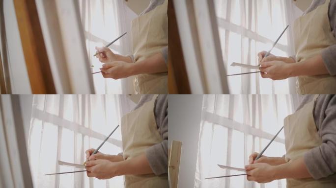 女艺术家的手在工作室工作期间，女人在画布上画画，细节在工作室拍摄