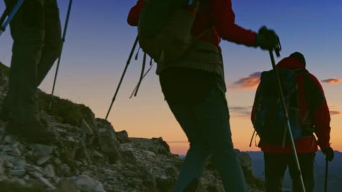 SLO MO徒步旅行者在黄昏时在陡峭的岩石斜坡上下山