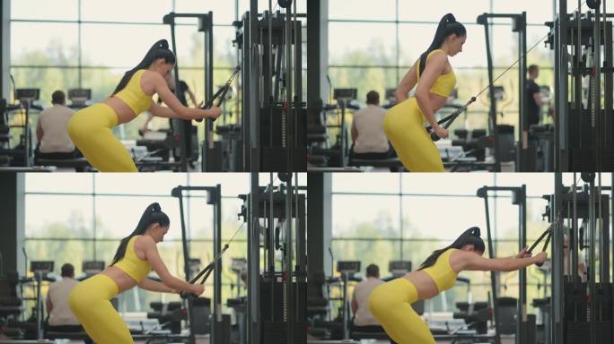 黑发女人在健身房训练她的背部和肩膀。监控你的背部和肩部健康。手部锻炼