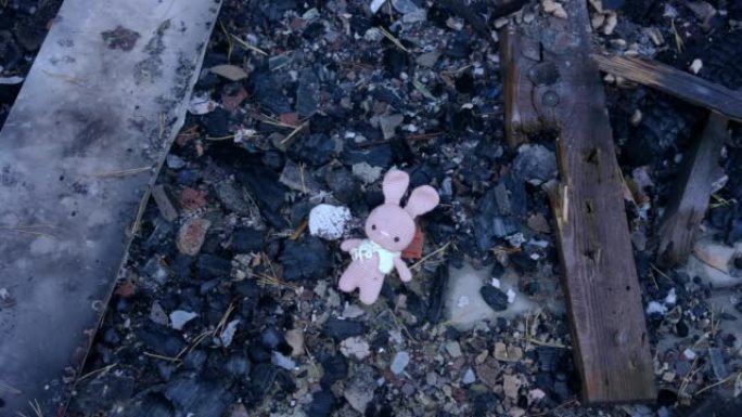 躺在被烧毁的土壤上的儿童玩具