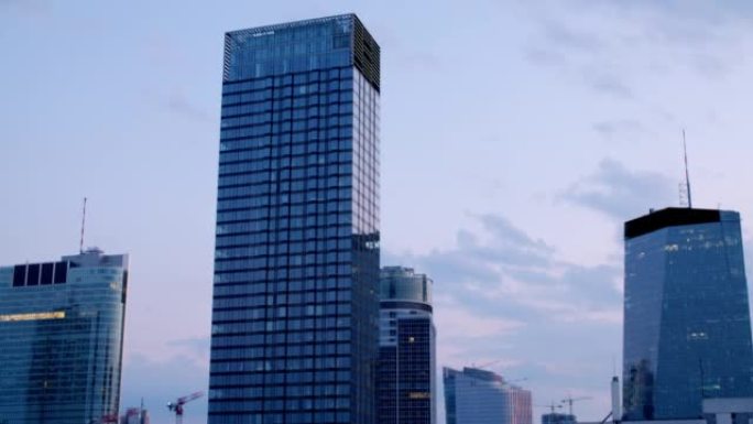 黄昏时正在建造的具有现代摩天大楼的城市的空中拍摄
